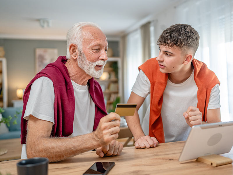 grandson teaching grandson about financial responsibility with credit cards