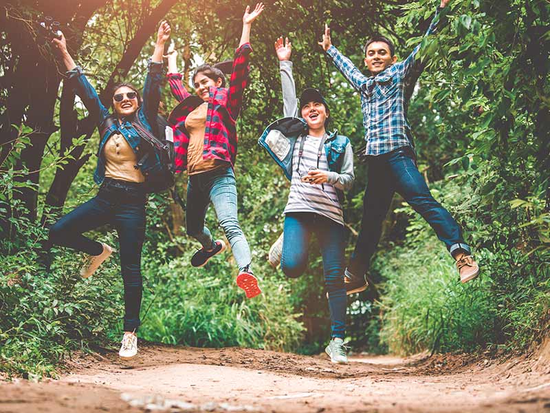 teenagers jumping in the air during a hike