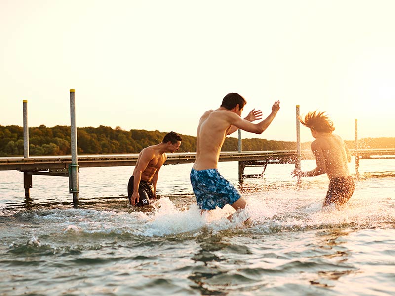 Three teenage boys playing in the water