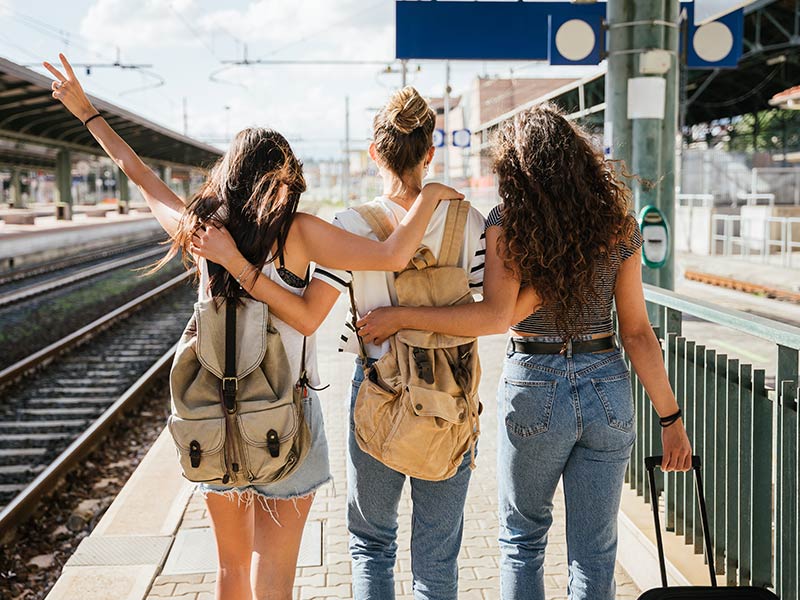 Three young female teens at station to catch train for their vacation together