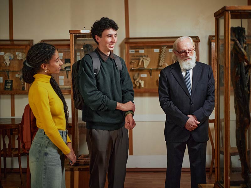 teenagers learning from a docent at a museum