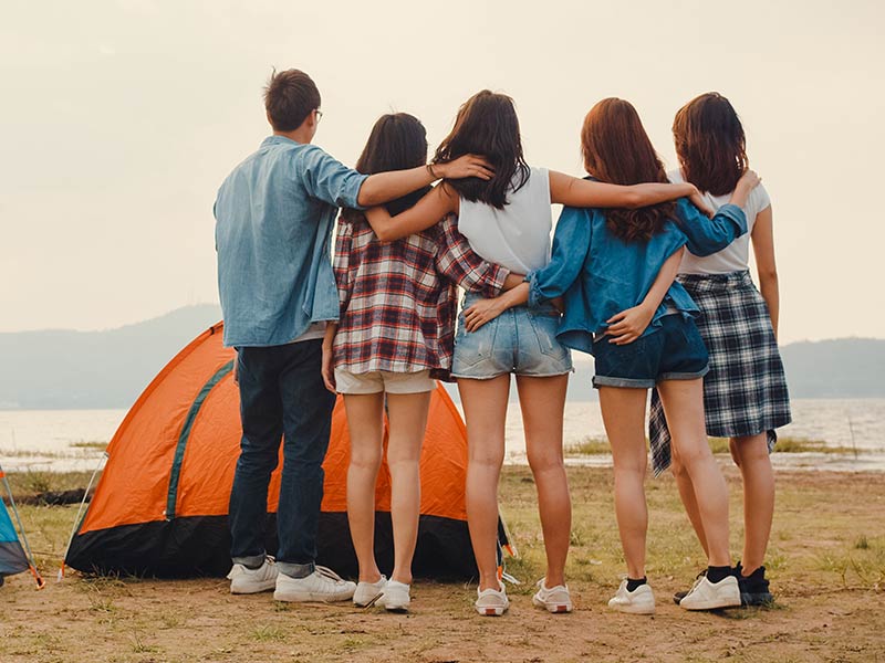 teenage campers looking at the ocean from their camp ground
